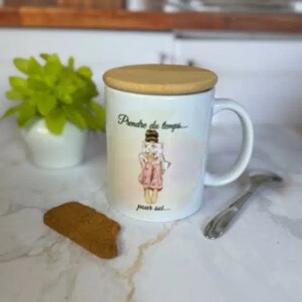 Mug avec couvercle en bois, plante et biscuit